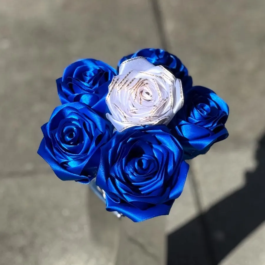 Bouquet de roses en satin bleu roi avec une rose blanche à liseré doré