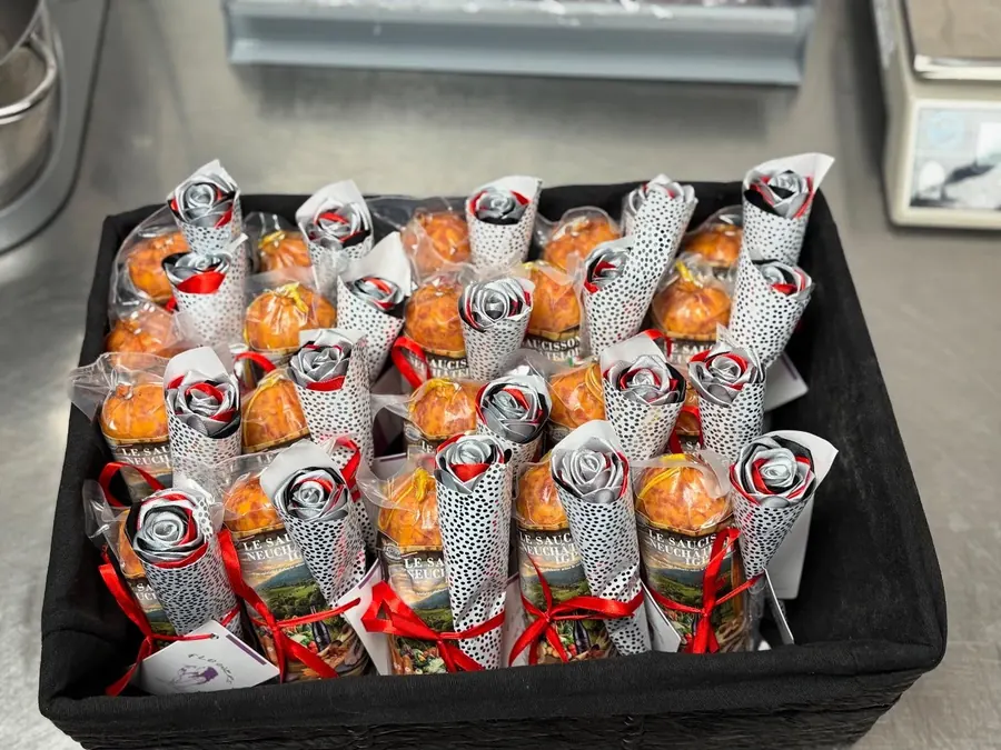 Roses en satin rouge, argent et noir dans des cornets, offertes avec des saucissons neuchâtelois