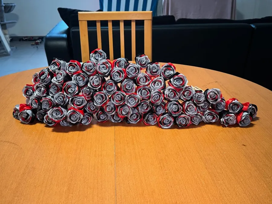 Lot de roses en satin rouge, argent et noir alignées sur une table