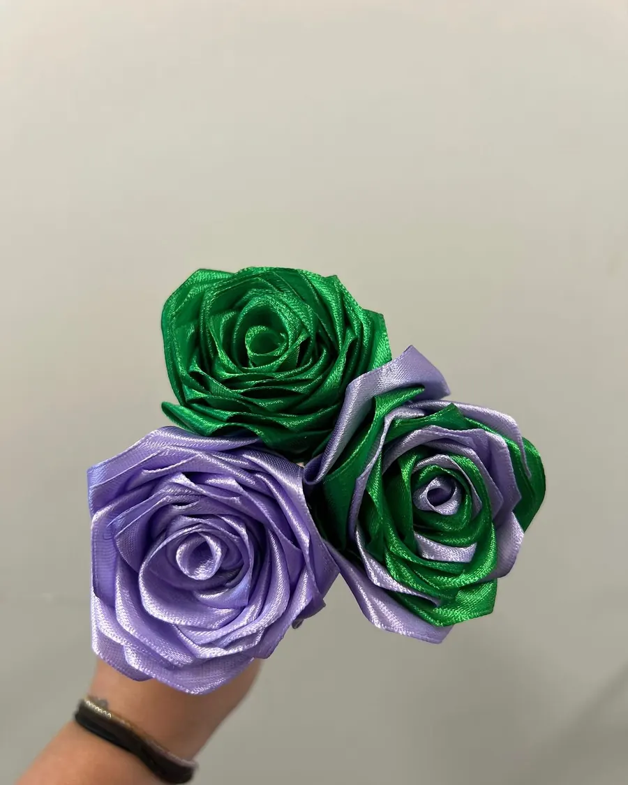 Trois roses en satin vert émeraude et lilas, dont une bicolore
